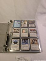 Binder opened showing nine Ice Age MTG cards in first pocket page