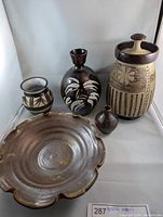 Overall view of the lot showing five ceramic pottery items including a scalloped edge bowl, two vases, one small vase, and a lidded jar.