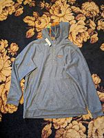 Full view of the heathered blue Patagonia men's hemp hoodie laid flat showing front with hood and front pouch pocket.