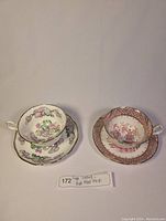 Two vintage teacup and saucer sets arranged side by side on white background, showing detailed patterns and colors of each set