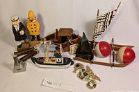 Photo showing entire lot with various nautical-themed wooden and metal items including small boats, sailor figurines, and a pelican figure.