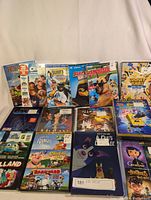 Photo showing multiple kids DVDs arranged in two rows, featuring titles such as Caroline, Mulan, Casper, SpongeBob SquarePants, Looney Tunes, Coraline, and others.