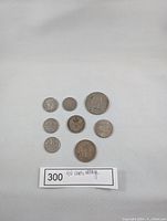 Eight vintage European coins laid out on white surface with label '300 EU coins vintage'. Coins vary in size and design.