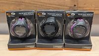 Photo of all three Champion pulse rate monitors in display packaging, showing front of devices and wrist straps.