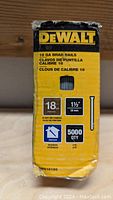 Photo of DeWalt box showing product specifications: 18 gauge, 1 1/2 inch length, 5000 quantity, indoor use, new condition.