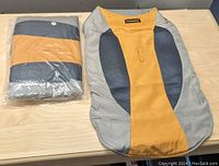 Two Havenfly dog cold weather winter coats in Large size. One coat folded and packaged in plastic, the other unfolded showing adjustable strap and design features.