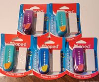 Image showing five Maped retractable erasers each with a white eraser refill in original packaging, assorted in color including purple, teal, and blue holders.