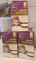 Three boxes of Sentry Calming Collars for cats stacked, showing front labels with product information and cat image.