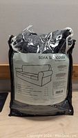 Packaged XL sofa slip cover set with label showing included items and product details.