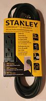 Front view of Stanley Cordmax Holiday 15-foot low profile grounded extension cord showing product label with features including flat plug, 3 outlets, and length.