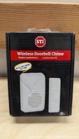 Front view of the STI wireless doorbell chime boxed packaging showing model number, range up to 500 ft, and 433 MHz frequency.