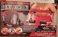 Box front showing the Kruncher Ultimate AB Machine and a man using it for abdominal exercises. Highlights 7-in-1 workout function and resistance levels.