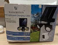 Box of Wasserstein Solar Light with Charging Cable showing compatibility with Ring cameras and product image with solar panel and dual LED lights.