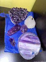 Full lot view with all six amethyst and stone pieces arranged on blue cloth.