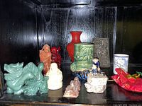 Full lot showing all figurines and vase on black shelf.