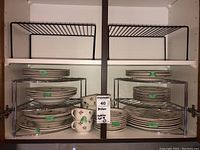 Wide cabinet view showing two wire racks stocked with plates and cups