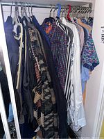Hanging men's clothing items on a rack including sweaters, shirts, and ties, mostly size 2XL.