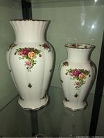 Two Royal Albert Old Country Roses vases side by side showing overall floral pattern and size difference