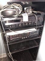 Shelf holding Yamaha RX-330 stereo receiver on top and a double cassette deck below, with cables and components on top.