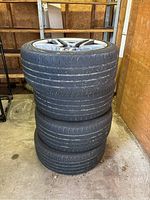 Four stacked Continental tires mounted on rims, showing overall condition in storage environment.