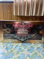 Full front view of the unopened Monopoly box showing Star Wars Episode I branding and Monopoly logo with sealed packaging.