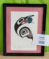 Framed print of 'Raven Stealing Sun' showing the entire artwork with the raven design and black plastic frame with pink mat.