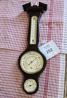 Full view of vintage Ergo wall-mounted barometer, thermometer, and humidity gauge with wooden frame on cloth background.