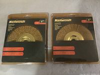 Two new Mastercraft 6 inch wire wheel brushes in original package, showing front view with visible wire bristles and brand name.