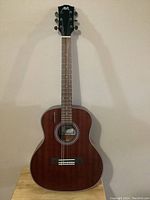 Front view of Aklot AKAG-4 acoustic guitar showing body, fretboard, and headstock with logo.