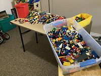 Overall view of three bins and tabletop covered with assorted LEGO parts