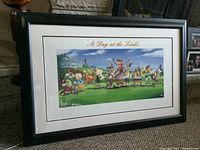 Full view of framed Looney Tunes lithograph titled "A Day at the Links" showing the artwork and frame on carpet near a fireplace.