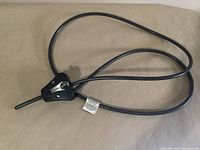 Full view of Master adjustable security cable lock with flexible black cable and triangular lock housing.