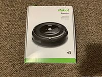 Front view of iRobot Roomba e5 box showing product image and model information.