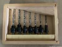 Set of seven tapered drill countersink/boring tools in a wooden case.