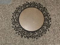 Top view of round mirror with detailed metal leaf design sunburst frame