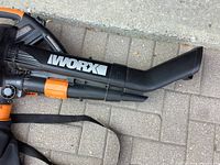Close-up of the blower tube showing the WORX logo and strap detail.