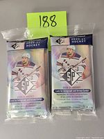 Front view of two sealed packages of 2020-21 SP Hockey trading card packs, each package containing 3 packs.