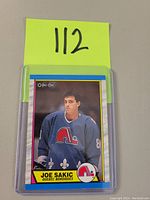 Front of the Joe Sakic rookie hockey card showing player image, team, and branding.