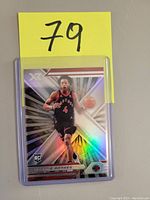 Front of Scottie Barnes rookie basketball card with holographic foil and action image of Barnes in a black Raptors uniform.
