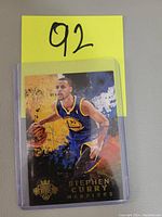 Front of Stephen Curry insert basketball card showing player image in Warriors uniform with colorful artistic background.
