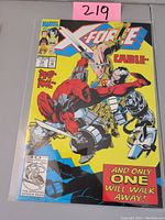 Front cover photo showing Deadpool and Cable on the cover of X-Force #15 comic book with bold yellow background and Marvel branding.