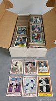 Box with two stacks of baseball cards visible, showing multiple cards including players from the lot.