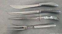 Four-piece Japanese kitchen cutlery set with hammered metal handles featuring two large knives, one dagger-style blade with guard, and one carving fork.