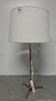 Full view of the Robert Abbey vintage table lamp showing white drum shade and metal base on a flat surface.