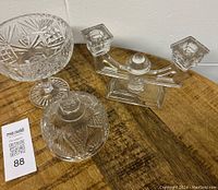 Crystal compote dish with lid and two crystal candlestick holders placed on a wooden surface