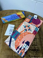 Photo showing the tea towel folded with colorful Disney designs including Ferris wheel and castle, next to the desk sign with the quote