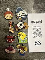 Top view of all 8 Disney trading pins arranged vertically with auction QR code and lot number 83