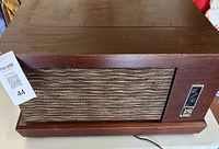 Front view of vintage Hi-Fi record player with wooden casing and fabric speaker grille.