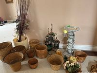 Wide view showing entire lot including bird bath, metal lantern stand, wicker baskets, faux flowers and planters.