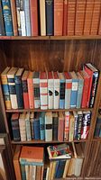 Bookshelves showing three rows of hardcover books including classic literature and mystery titles